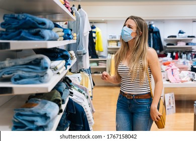 Young Woman In Mask Shopping At A Clothing Store In The Coronavirus Pandemic