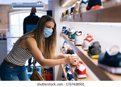 Young Woman In Mask Shopping At A Clothing Store In The Coronavirus Pandemic