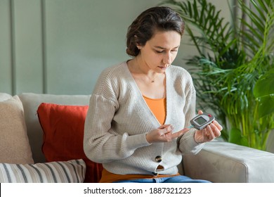 Young woman measures blood sugar level. Diabetes using glucometer.