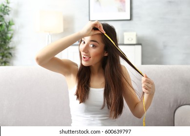 Young Woman Measuring Hair Length At Home