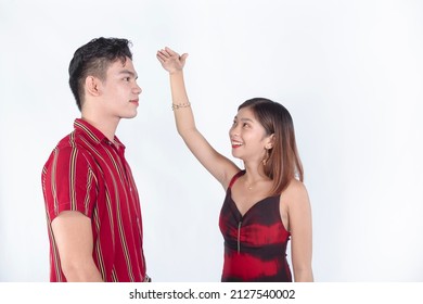 A Young Woman Measuring Her Friend's Height Difference With Her Hand. Sizing Up And Amazed At How Tall He Is. Gifted With Great Genes.