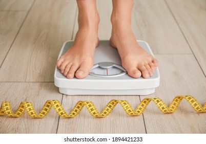 Young Woman Measuring Her Weight At Home