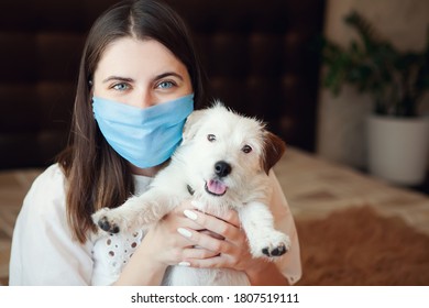 Young Woman In Medical Mask With Dog Jack Russell Broken Stay Isolation At Home For Self Quarantine. Concept Home Quarantine, Prevention COVID-19, Coronavirus Outbreak Situation