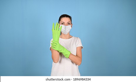 Young Woman In Medical Mask, Puts On Protective Green Gloves, Preparing For Coronavirus Epidemic Or Cleaning. Cleaning Service, Housekeeping Concept. . High Quality Photo