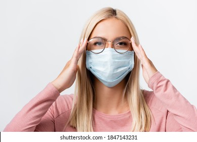 Young Woman In Medical Mask Touching Eyeglasses Isolated On Grey