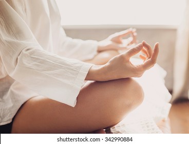 Young woman meditating at home. Beautiful fit girl doing exercises, practicing yoga. Harmony, balance, meditation, yoga practice, relaxation at home, healthy lifestyle concept