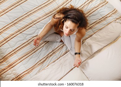 A Young Woman Meditating On The Bed.