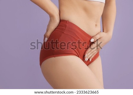 Young woman in menstrual panties on lilac background, closeup
