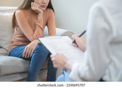 Young woman in a mental therapy session talking with a psychologist in the office. - Shutterstock ID 2100695707