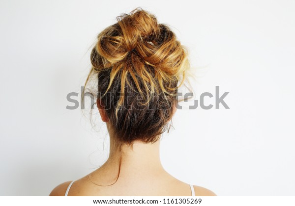 Young woman with messy\
bun hairstyle.