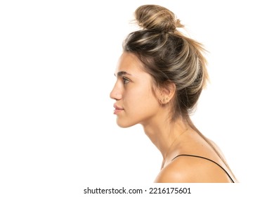 Young woman with messy loose bun and no makeup on a white studio background. side profile view - Powered by Shutterstock