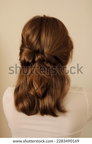 Young woman with mid-length dark blonde hair in a half-up hairstyle. Twisted half-up ponytail. Hairstyle. Casual hairstyle. White shirt. Back view of a hairstyle. No face. 