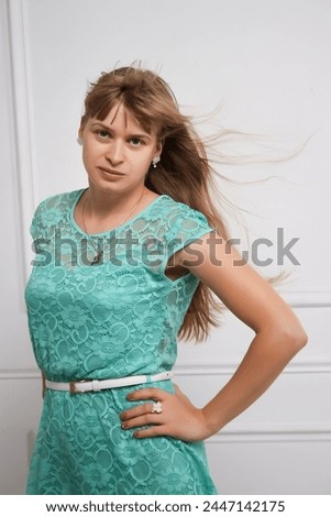 young woman in mint dress on white background