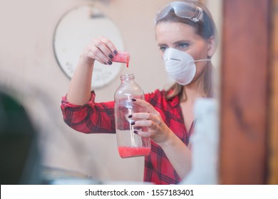 Young Woman Mixing Chemicals In Illegal Laboratory