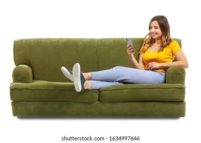 Young woman with mobile phone sitting on sofa against white background