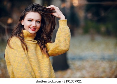 Young Woman Model In Autumn Park With Yellow Foliage Maple Leaves. Fall Season Fashion