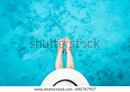 young woman model in bikini chill on beach with white hat sitting alone on a the wooden bridge over the clear aqua sea like a pool in Maldive.