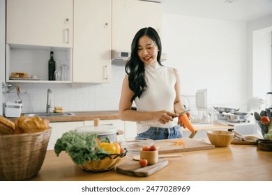 A young woman in a modern kitchen peeling carrots and preparing fresh vegetables, surrounded by healthy ingredients and natural light. - Powered by Shutterstock