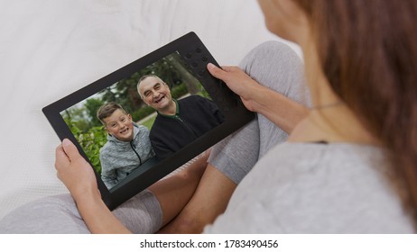 Young Woman Mom Video Calling On Laptop Talking By Webcam With Happy Child Boy And Granfather On Computer Screen. Videocall, Family Chat Concept. Over Shoulder Close Up View.