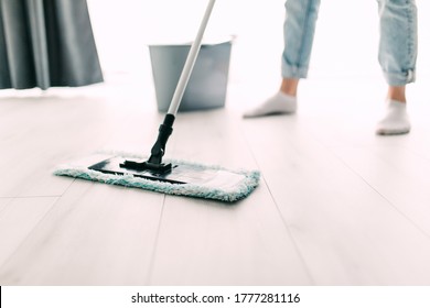 Young Woman Mopping Hardwood Floor At Home