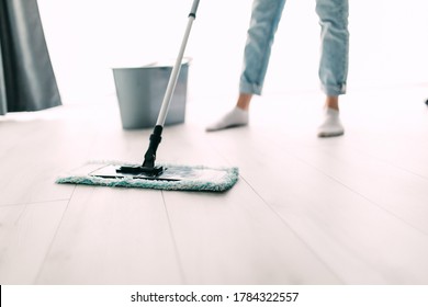 Young Woman Mopping Hardwood Floor At Home