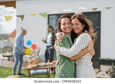 Young woman with mother outdoors in garden at home, birthday celebration party. - Powered by Shutterstock