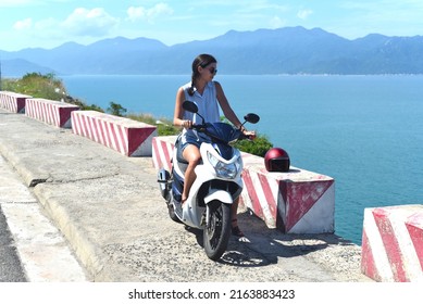 Young Woman Motorbike Driver Sitting Against South South China Sea In Vietnam