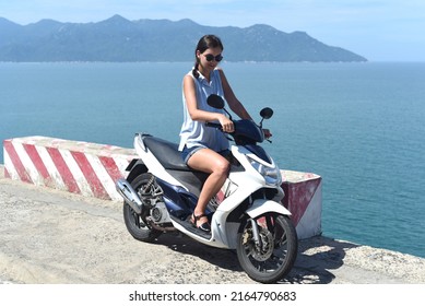 Young Woman Motorbike Driver Sitting Against South South China Sea In Vietnam