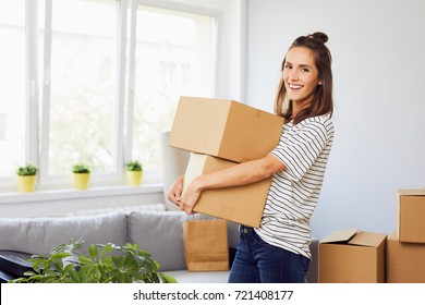 Young Woman Moving Into New Apartment Holding Cardboard Boxes With Belongings