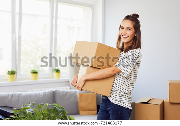 持ち物を持つ段ボール箱を持つ新しいアパートに引っ越す若い女性 の写真素材 今すぐ編集