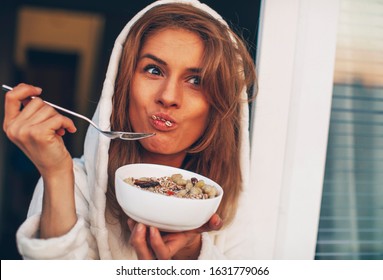 Young Woman With Muesli Bowl. Girl Eating Breakfast Cereals With Nuts, Pumpkin Seeds, Oats And Yogurt In Bowl. Girl Holding Homemade Granola. Healthy Snack Or Breakfast In The Morning..
