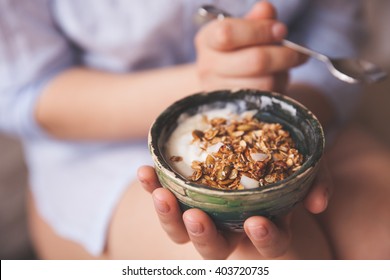 Young Woman With Muesli Bowl. Girl Eating Breakfast Cereals With Nuts, Pumpkin Seeds, Oats And Yogurt In Bowl. Person Holding Homemade Granola. Healthy Snack Or Breakfast In The Morning.