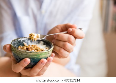 Young Woman With Muesli Bowl. Girl Eating Breakfast Cereals With Nuts, Pumpkin Seeds, Oats And Yogurt In Bowl. Girl Holding Homemade Granola. Healthy Snack Or Breakfast In The Morning.