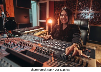 Young Woman Music Producer Working On A Mixing Soundboard While In Her Studio