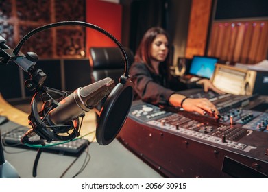 Young Woman Music Producer Working On A Mixing Soundboard While In Her Studio