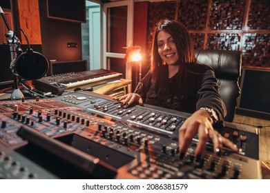 Young Woman Music Producer Working On A Mixing Soundboard While In Her Studio