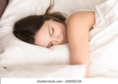 Young Woman Napping While Hugging Soft Pillow, Resting In Cozy Bed With Fresh White Sheets, Smiling In Her Sleep. Healthy Sleep, Deep Relaxing And Strength Renewal After Hard Work Week Concept