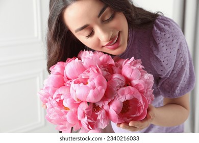 Young woman near bouquet of pink peonies indoors, closeup - Shutterstock ID 2340216033