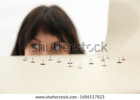 Young woman near chair with pins, closeup. April fool's day