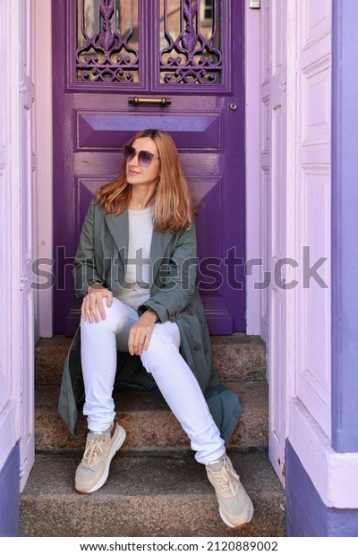 Young woman near purple
door