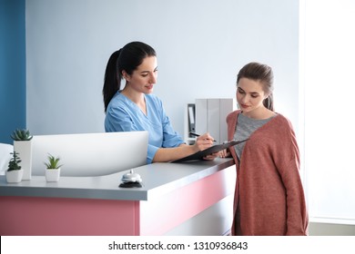 Young Woman Near Reception Desk In Clinic