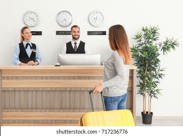 Young Woman Near Reception Desk In Hotel