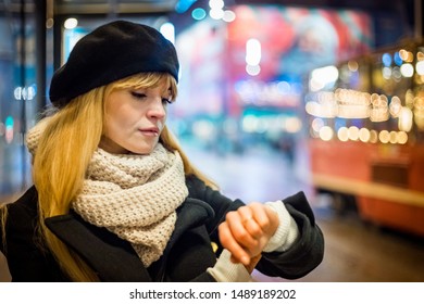 Young woman in the night city waiting at bus stop