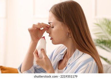 Young Woman With Nosebleed And Tissue At Home, Closeup