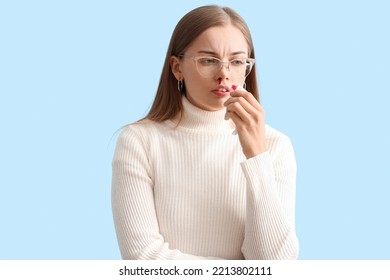 Young Woman With Nosebleed And Tissue On Blue Background