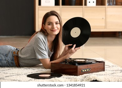 Young Woman With Old Record Player And Vinyl Discs At Home