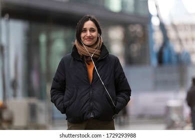 Young Woman With Olive Complexion Smiling At Camera Outdoors In City. 