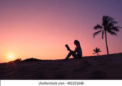 Young Woman On The Beach Reading A Book. 