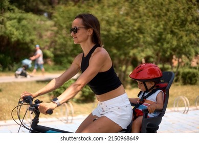 Young woman on a bicycle with little son. High quality photo