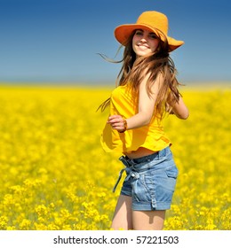 Young Woman On Blooming Rapeseed Field In Summer